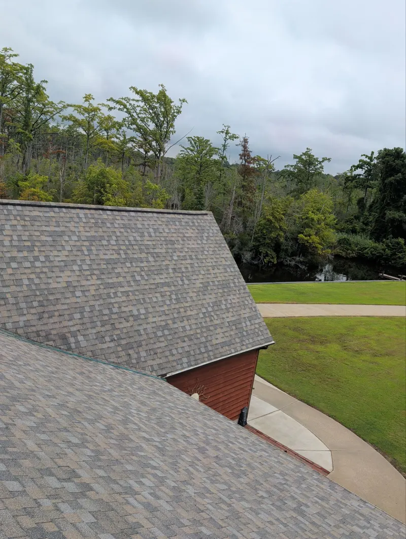 Finished brown shingle roof over a gable, with a lawn and waterway beyond