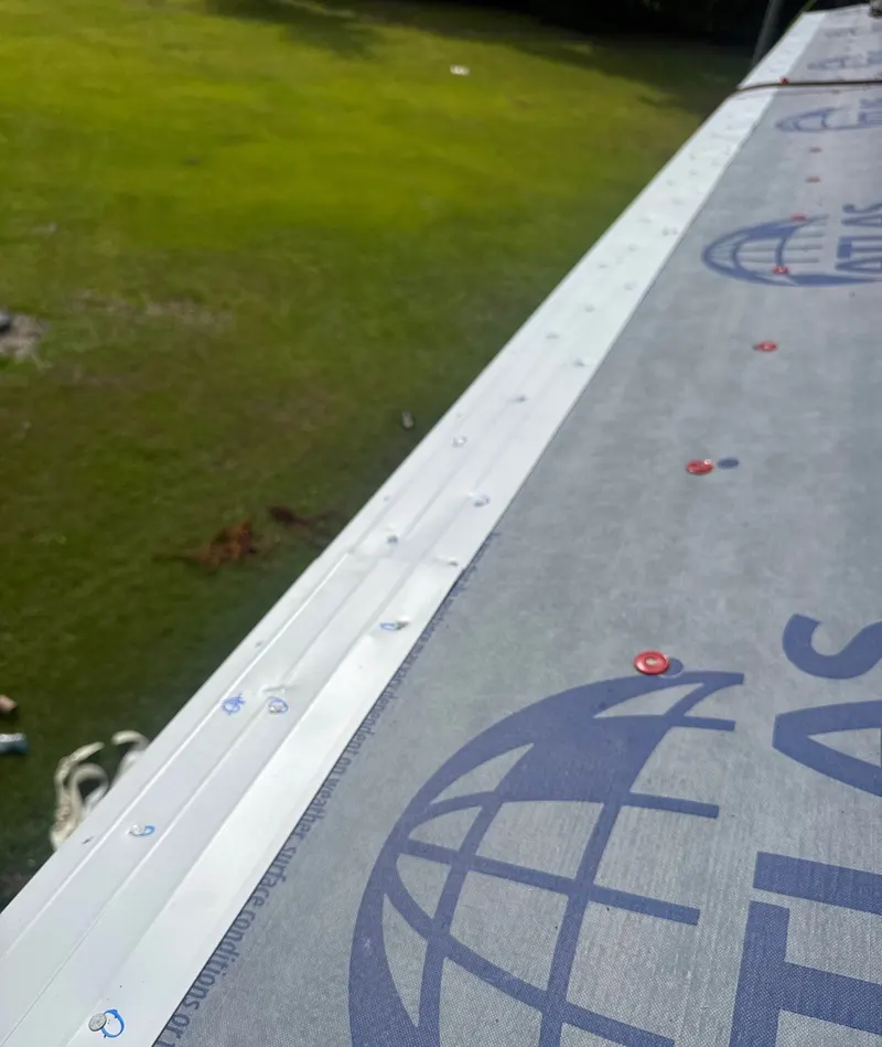 White drip edge along the eave over synthetic underlayment