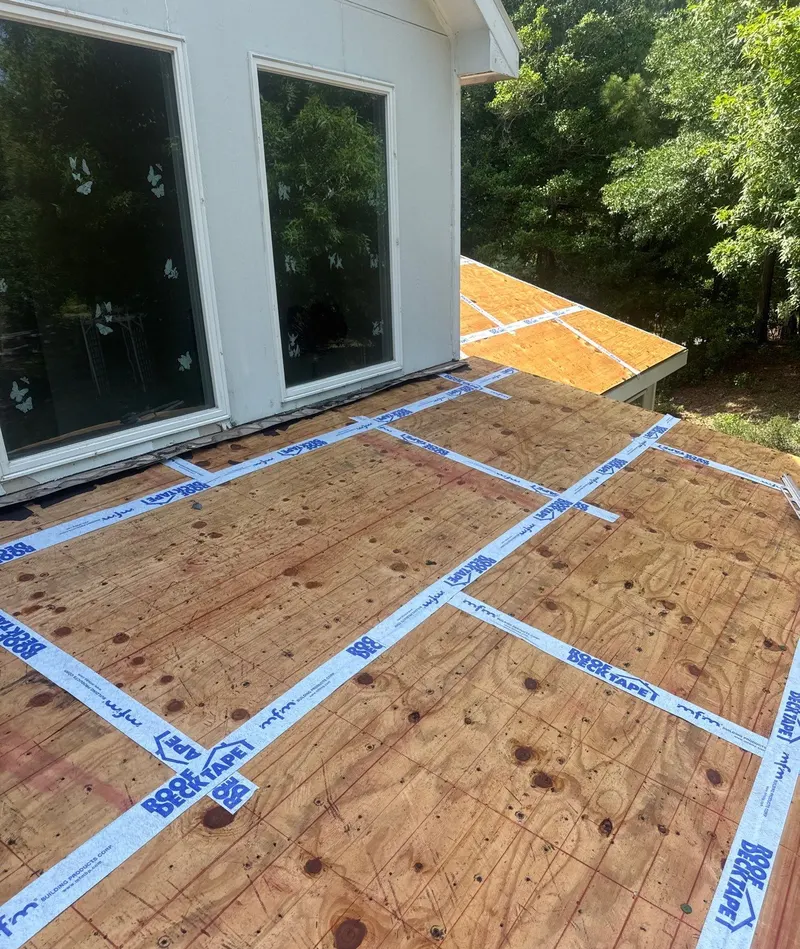 Roof deck tape sealing plywood seams beside a large gable window