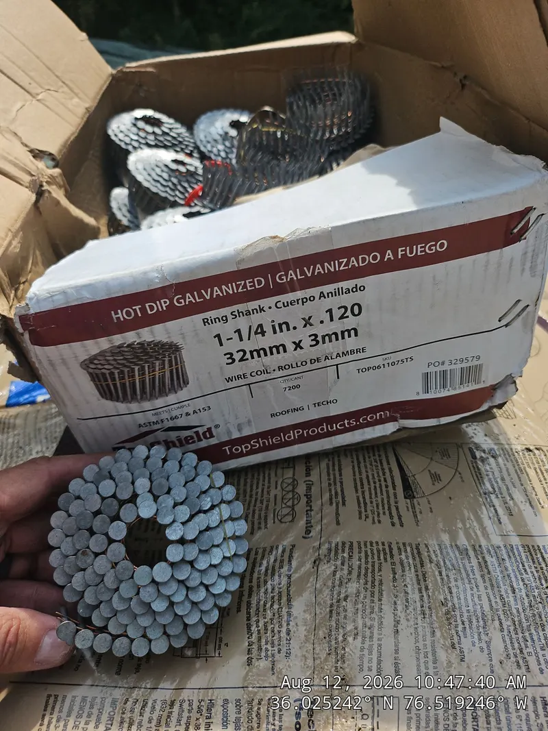 A box of hot-dip galvanized ring-shank coil roofing nails with a coil held in a hand