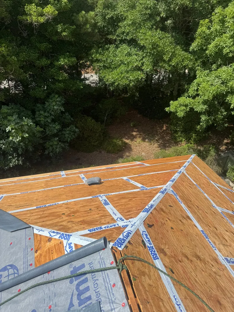 Taped plywood deck seams beside synthetic underlayment going down